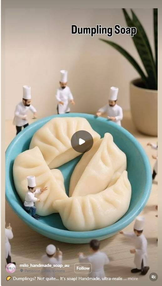 Dumpling-shaped soap in a blue bowl with miniature figures around it, featuring the brand 'milo handmade soap'.