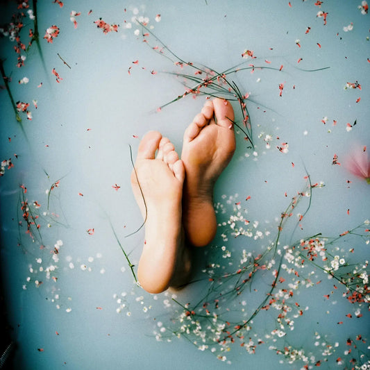 Feet in a bath with flowers